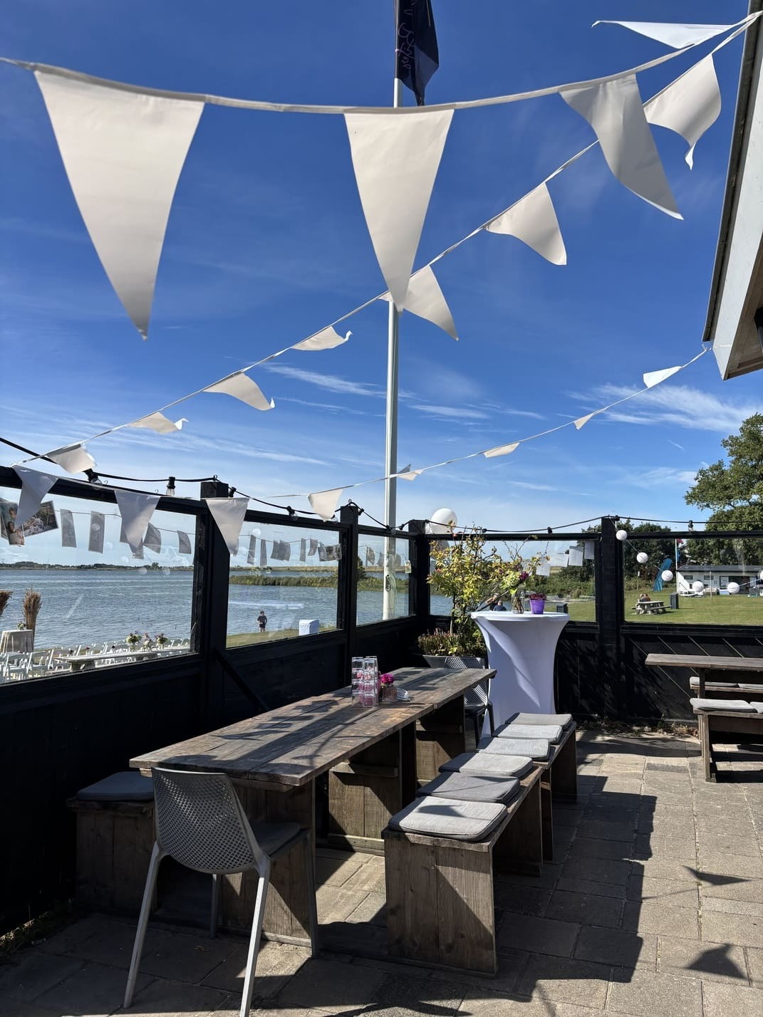 Terras met witte vlaggetjes en heldere blauwe lucht